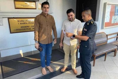 Muhammad Ahsan (kiri) dan Saghir Shaheen (tengah) didakwa di Mahkamah Sesyen Kuala Lumpur pada Isnin, atas pertuduhan memiliki lebih 800 minyak wangi tiruan.