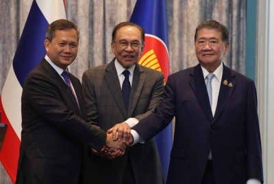 Anwar (tengah) menyaksikan Hun Manet (kiri) bersalaman dengan Phumtham Wechayachai (kanan) selepas Mesyuarat Khas Bersama di Kompleks Seri Perdana. Foto Bernama