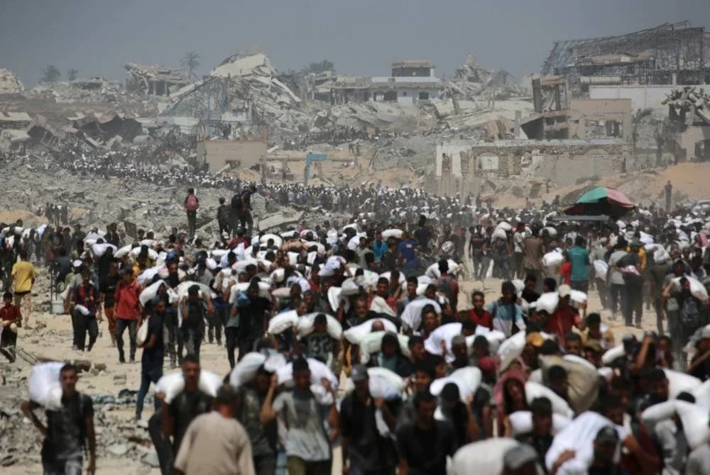 Penduduk Palestin beramai-ramai membawa guni tepung yang diedarkan kepada mereka di kawasan utara wilayah itu. Foto AFP