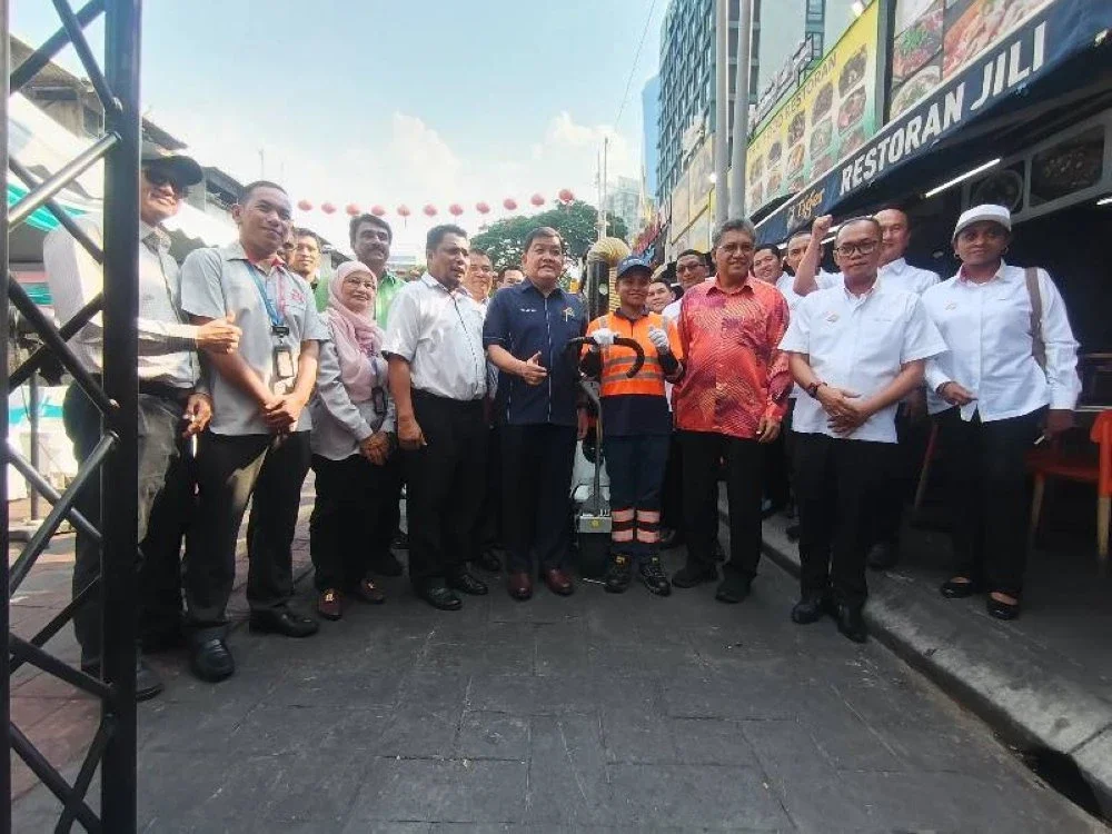 Loy Sian (tengah) bersama sebahagian kakitangan SWCorp selepas Majlis Pelancaran Glutton Electric Vacuum di Pusat Penjaja Jalan Alor, Bukit Bintang di sini, pada Isnin.