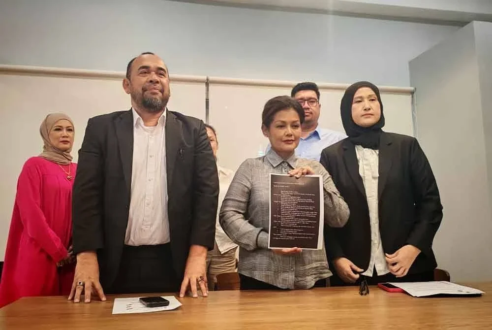 Fatimah (tengah) bersama peguamnya ketika ditemui pemberita di sebuah restoran di Bukit Jelutong pada Selasa.