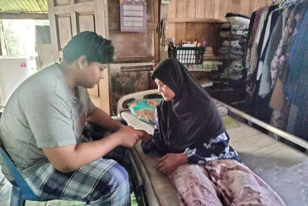 Muhammat Nuqman melihat tangan neneknya yang semakin pulih selepas lima bulan diserang gajah liar.