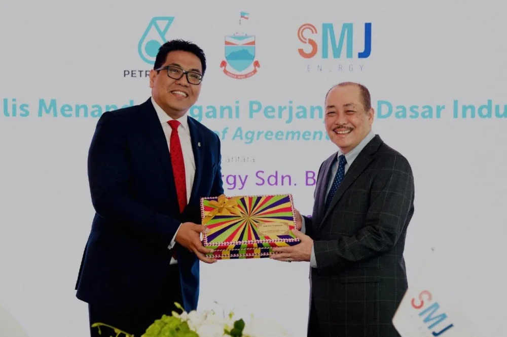 Hajiji (kanan) bersama Presiden dan Ketua Pegawai Eksekutif Kumpulan Petronas, Tan Sri Tengku Muhammad Taufik Tengku Aziz.