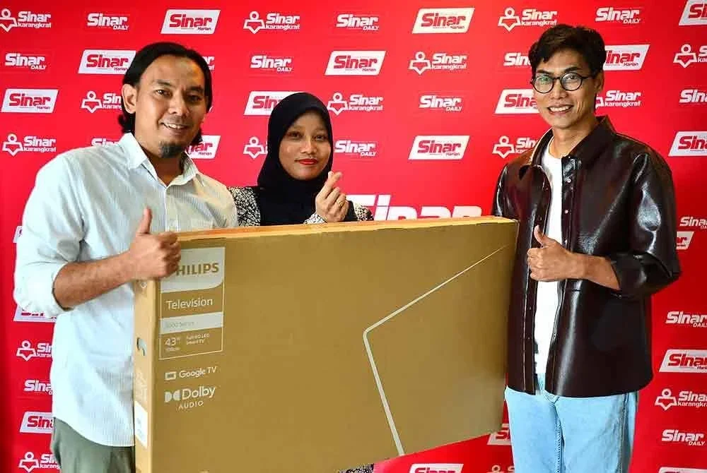 Nurul Atiqah ( tengah) dan suami menerima hadiah smart tv untuk tempat kedua daripada Pengarah Projek Karnival Siang Malam Karangkraf 2025, Meen Tahrin. - FOTO: SINAR HARIAN/ ASRIL ASWANDI SHUKOR
