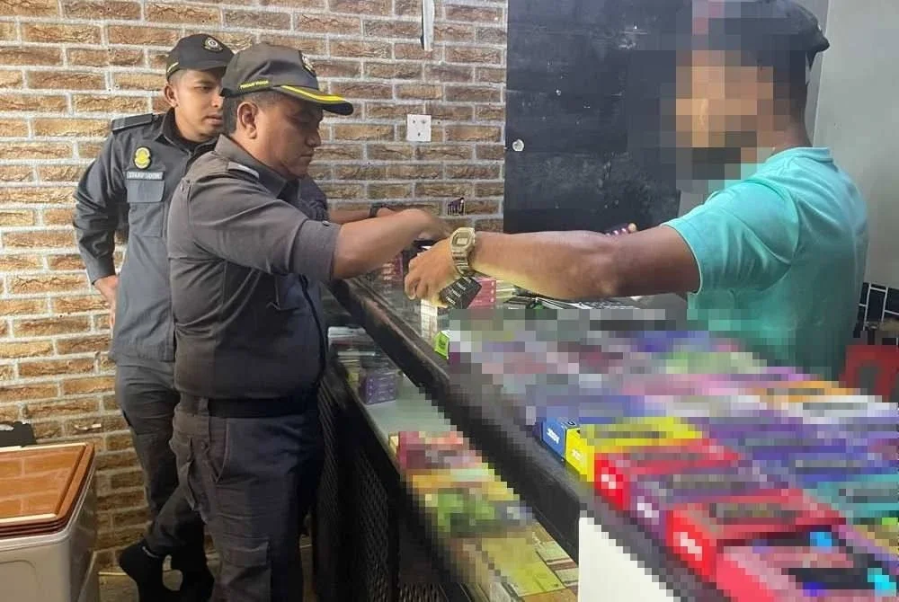 Anggota penguat kuasa KPDN Terengganu memeriksa cecair isian semula rokok elektronik disyaki tiruan yang dirampas dalam operasi bersepadu di sekitar Kuala Terengganu dan Kuala Nerus, pada Selasa.