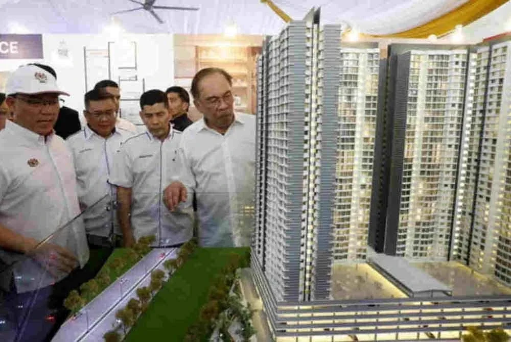 Anwar (kanan) melihat model rumah mampu milik pada Majlis Pecah Tanah Projek Pembangunan Rumah Belia Madani dan Rumah Mampu Milik di Mukim Batu, Kuala Lumpur pada April lalu. Foto Bernama