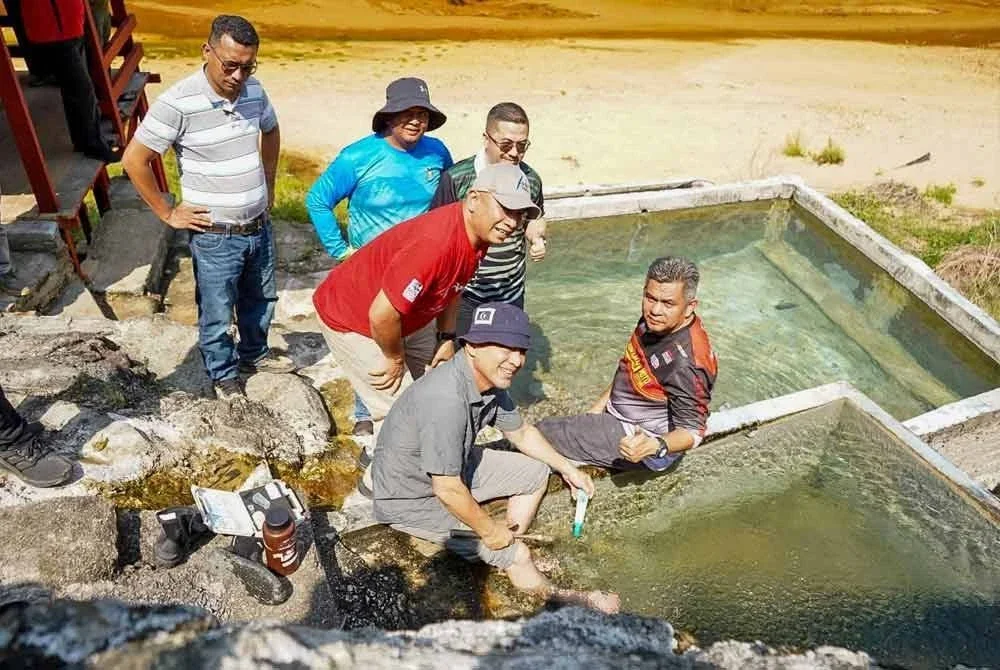 Razali (tengah) ketika meninjau lokasi penemuan kolam air panas semula jadi di Ladang Cenderung Putera North, Ban Hol, Cerul, Kemaman.