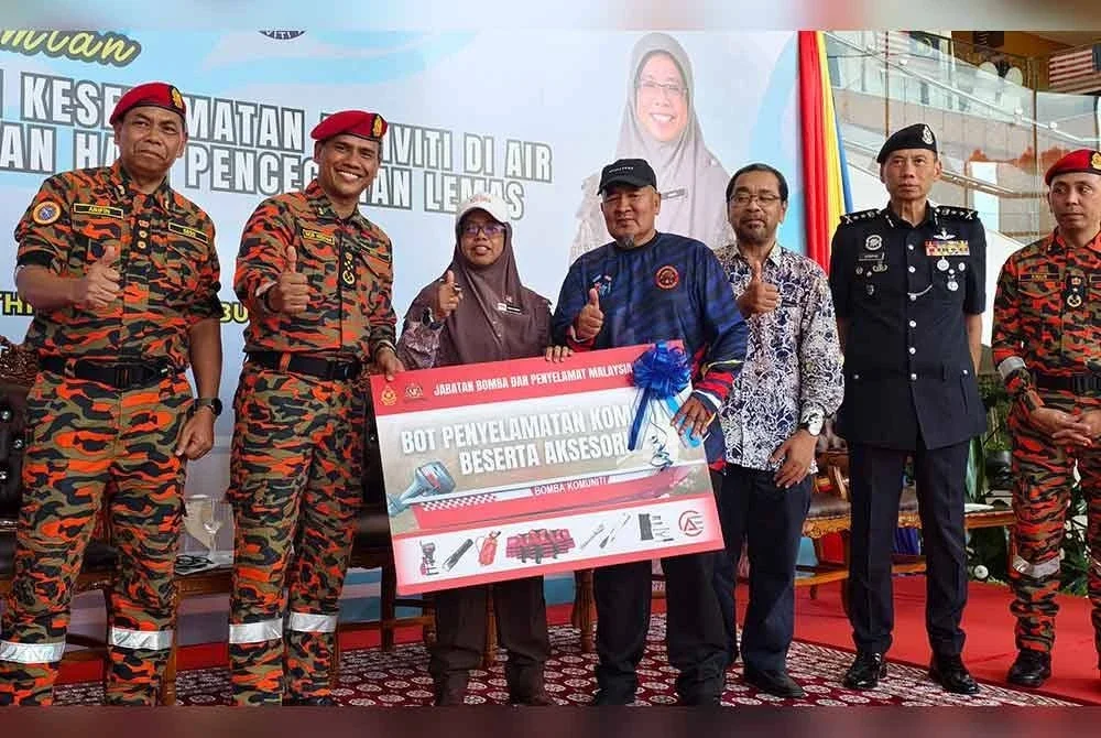 Nor Hisham (dua dari kiri) dan Aiman Athirah (lima dari kanan) menyerahkan bot Penyelamat komuniti kepada penerima