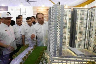 Anwar (kanan) melihat model rumah mampu milik pada Majlis Pecah Tanah Projek Pembangunan Rumah Belia Madani dan Rumah Mampu Milik di Mukim Batu, Kuala Lumpur pada April lalu. Foto Bernama