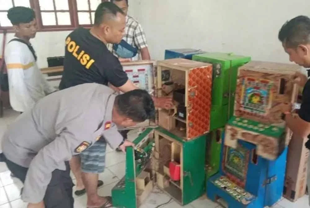 Polis memeriksa puluhan mesin judi yang diletakkan dalam sekolah kosong di Desa Lau Damak, Bahorok. Foto Agensi
