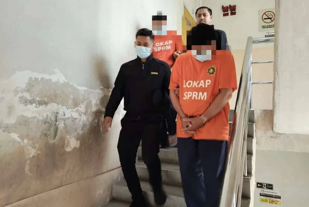 Kedua-dua suspek dibawa anggota SPRM selepas mendapat perintah reman dari Mahkamah Majistret Johor Bahru pada Khamis. Foto SPRM Johor