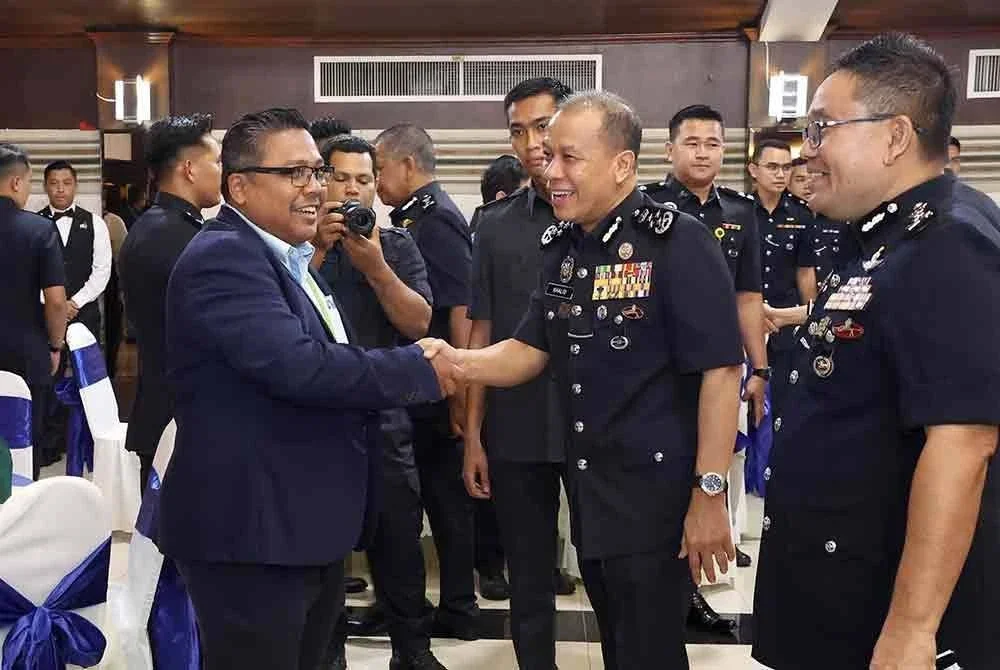 Mohd Khalid (kanan) beramah mesra dengan Zamri semasa Majlis Ramah Mesra di Bukit Aman pada Jumaat.