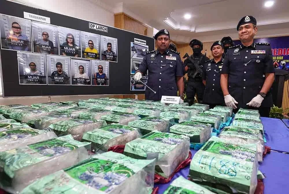 Hussein (kiri) menunjukkan antara dadah yang dirampas pada sidang media di Ibu Pejabat Polis Daerah Muar pada Jumaat. Foto Bernama