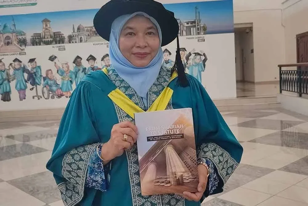 Nurdianawati menunjukkan bukunya From Shariah to Statute: Legal and Regulatory Framework of Islamic Finance in Malaysia.