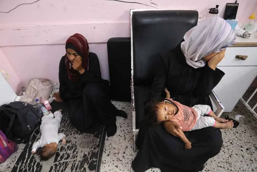 Wanita Palestin bersama anak mereka yang mengalami malnutrisi dirawat di Hospital Nasser, selatan Gaza.