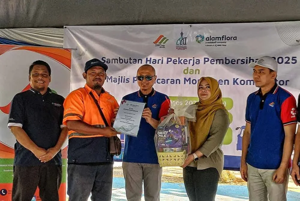 Azman (tiga dari kiri) menyampaikan Anugerah Pekerja Dedikasi kepada 27 pekerja pembersihan pada Majlis Pelancaran Program Sambutan Hari Pekerja Pembersihan 2025 dan Monumen Kompaktor di Taman Gelora pada Sabtu.