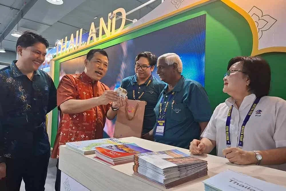 Sze Yee (dua dari kiri) ditemani Wandy (kanan) meninjau ruang pameran MATTA Fair Perak di Pusat Konvensyen Ipoh pada Sabtu.