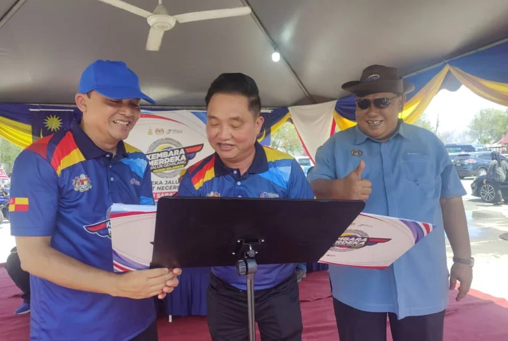 Suee Lim (tengah) menandatangani simbolik perasmian Kembara Merdeka Jalur Gemilang Peringkat Negeri Selangor di Pantai Redang, Sekinchan pada Sabtu.