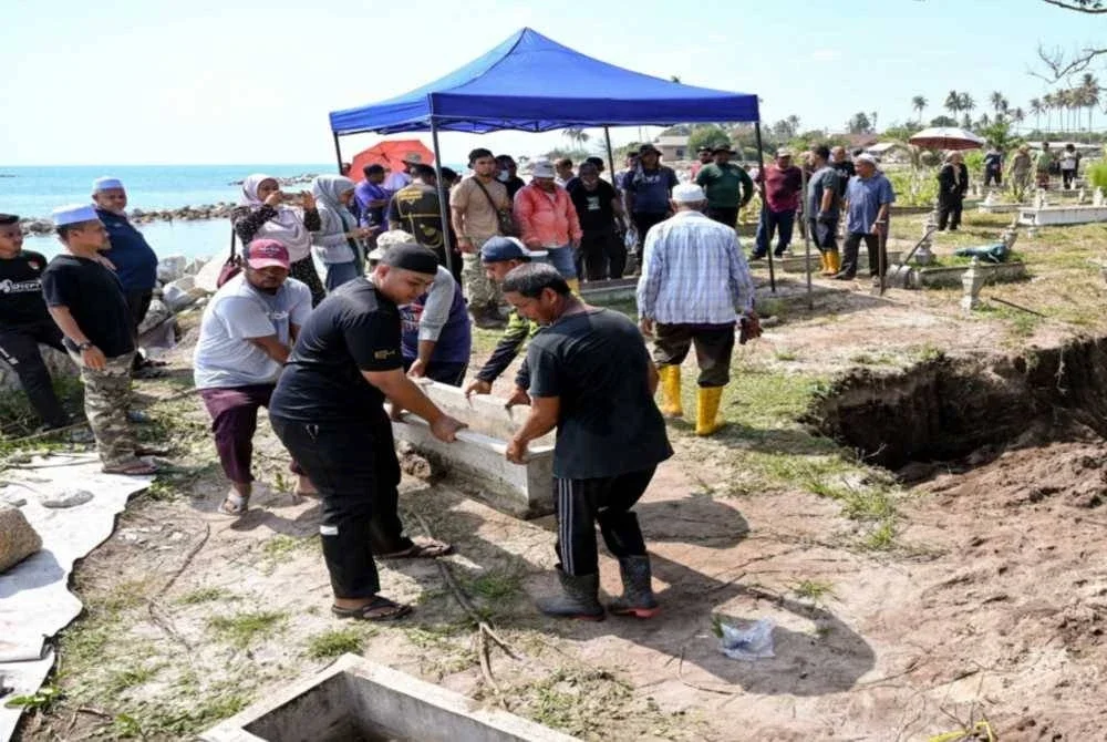 Waris dan ahli keluarga yang dipantau oleh pegawai Pejabat Agama Daerah Kuala Nerus mengangkat kepok kubur bagi proses dokumentasi jenazah selepas kubur digali semula untuk dipindahkan ke kawasan perkuburan lain semasa tinjauan di Tanah Perkuburan Islam Kampung Pengkalan Maras pada Sabtu. Foto Bernama