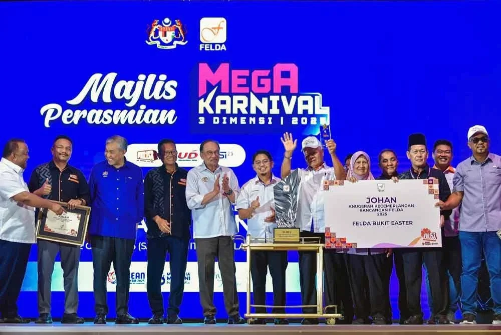Anwar (lima dari kiri) menyampaikan anugerah kecemerlangan rancangan Felda 2025 kepada wakil Felda Bukit Easter pada Majlis Perasmian Mega Karnival 3 Dimensi 2025 di Pusat Pameran dan Perdagangan Antarabangsa Malaysia (MITEC) pada Sabtu. Foto Bernama