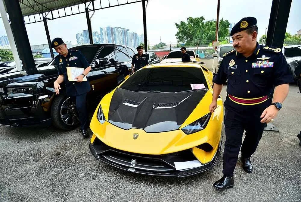 Muhammad Kifli menunjukkan antara kenderaan mewah yang disita dalam operasi dijalankan sebelum ini.