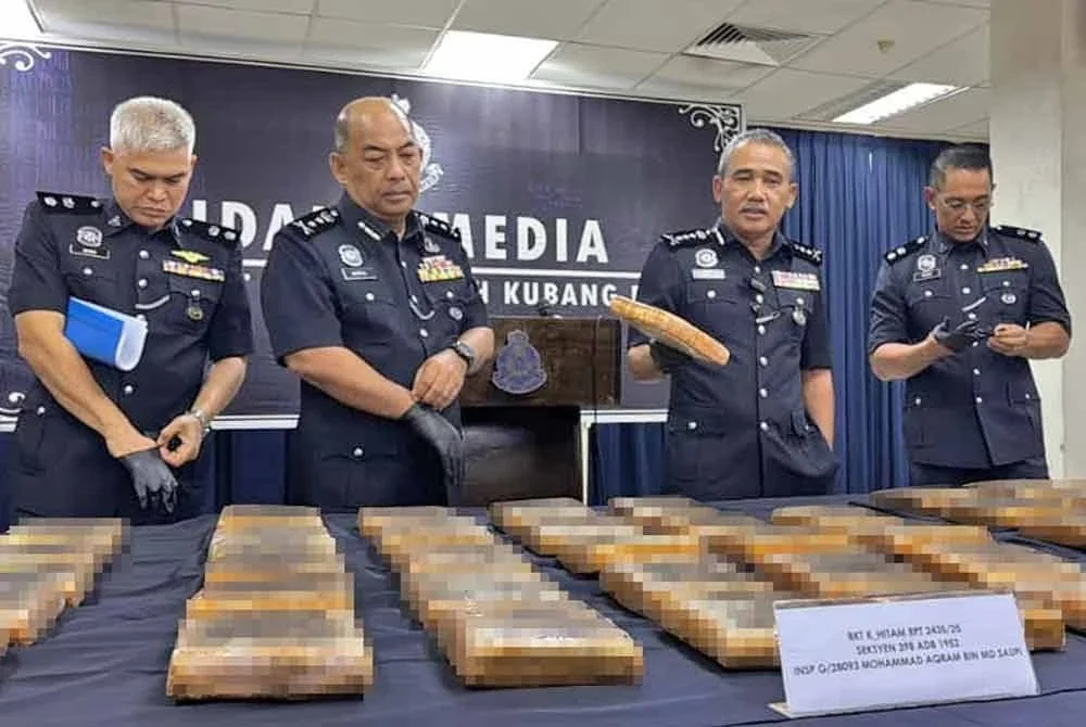 Adzli (dua dari kanan) menunjukkan bungkusan ganja yang berjaya dirampas di Bukit Kayu Hitam.