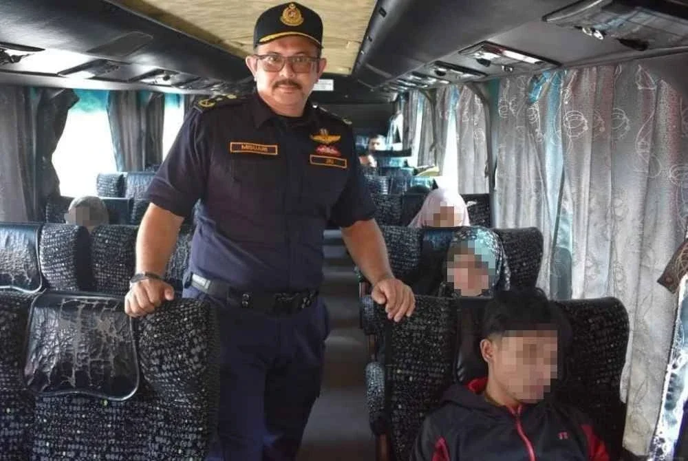 Misuari (kiri) memantau penggunaan tali pinggang keledar di dalam sebuah bas ekspres. Foto JPJ