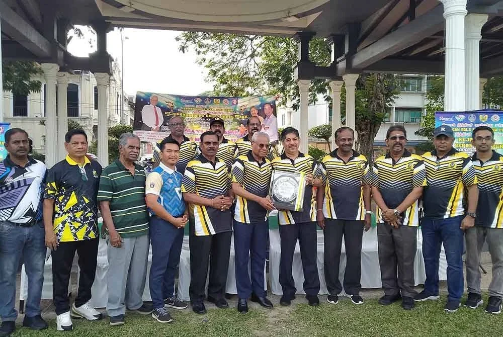 Amaluddin (lima dari kanan) menyampaikan cenderahati kepada Sivanesan (tengah) yang menyempurnakan perasmian Kejohanan Bola Sepak Tahunan Sekolah Jenis Kebangsaan Tamil Negeri Perak ke-17 di Padang Ipoh pada Ahad.