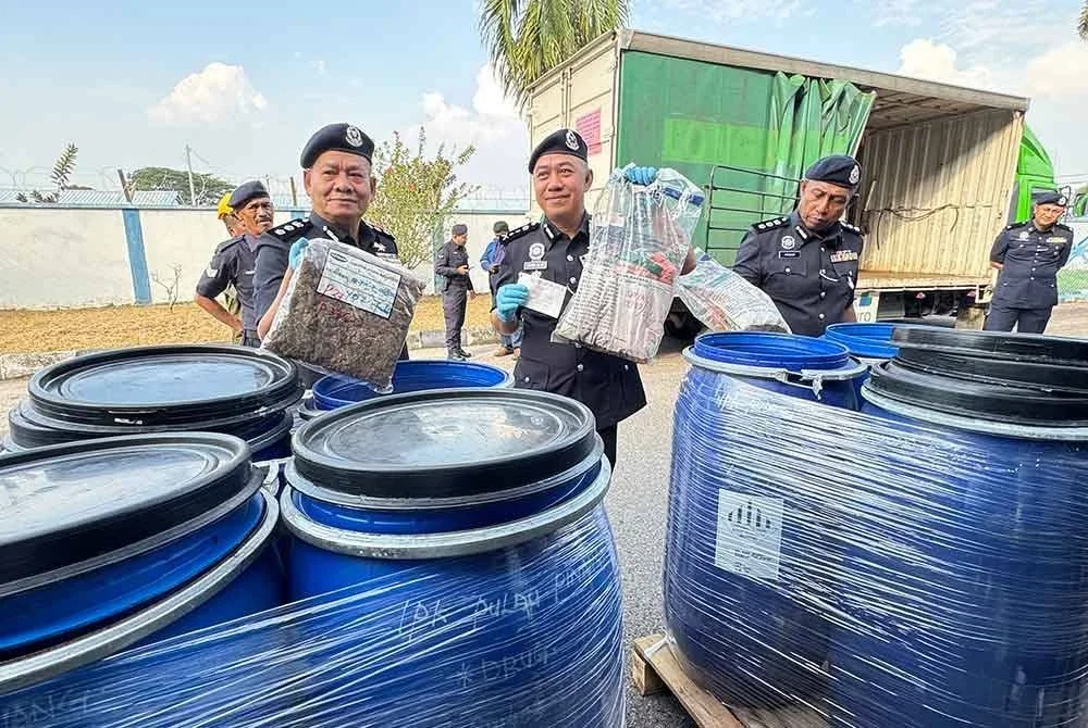 Mohd Alwi (tengah) menunjukkan dadah yang akan dilupuskan selepas sidang media di Stor Barang Kes Berpusat Kontinjen Seberang Perai Utara pada Isnin.