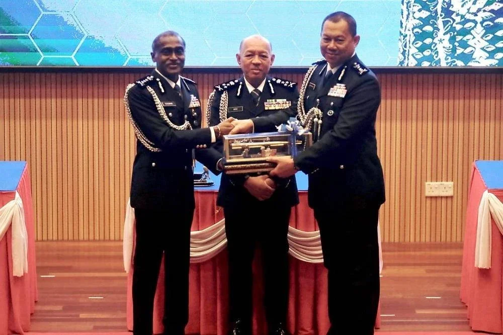 Abdul Aziz (tengah) menyaksikan penyerahan tongkat kuasa antara M Kumar (kiri) kepada Ab Rahaman (kanan) pada Majlis Serah Terima Tugas Ketua Polis Johor di IPK Johor pada Isnin.