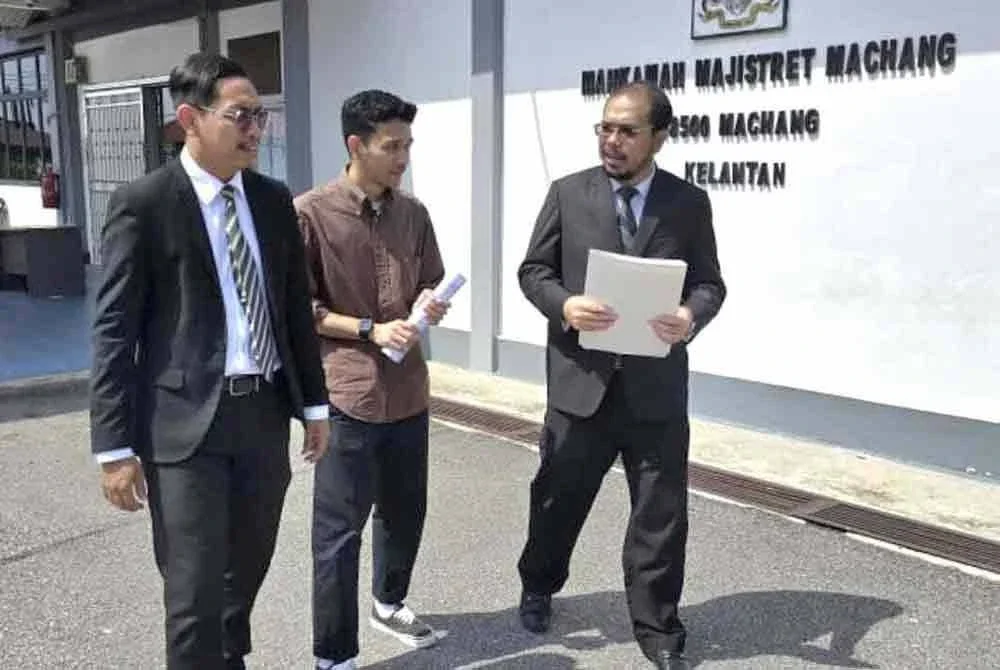 Mohamad Zakiran (tengah) bersama dua peguambela keluar dari Mahkamah Majisret Machang pada Isnin.