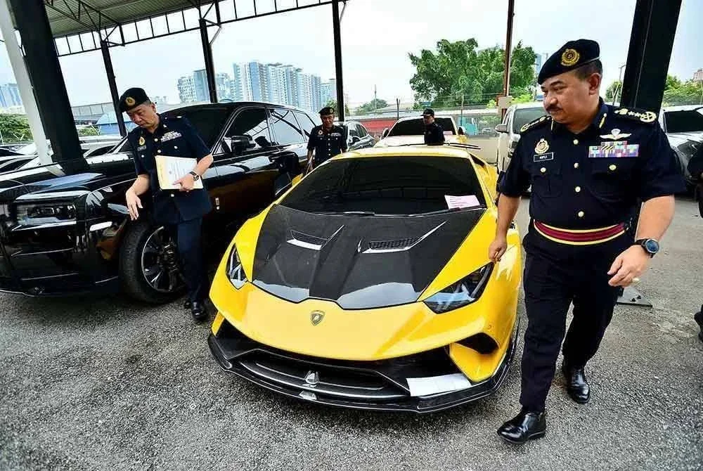 Muhammad Kifli menunjukkan antara kenderaan mewah yang disita dalam operasi dijalankan sebelum ini.