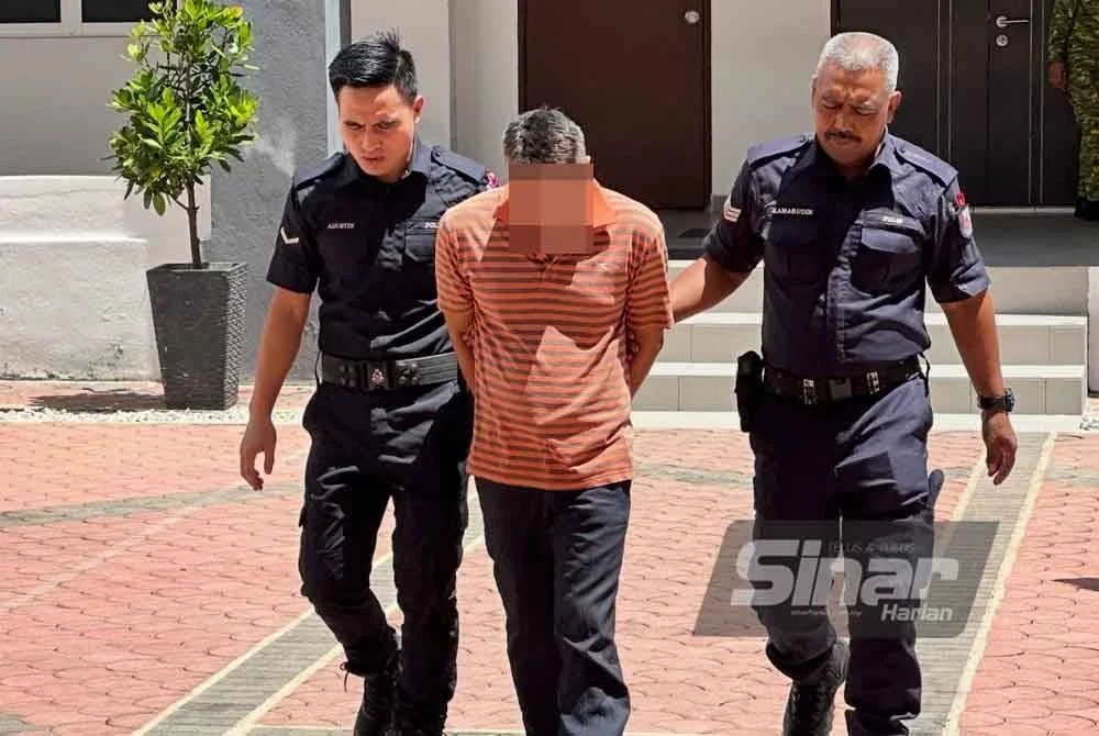 Tertuduh (tengah) ketika dibawa ke kaunter bayaran bagi menjelaskan jamin. FOTO SINAR HARIAN - ADILA SHARINNI WAHID