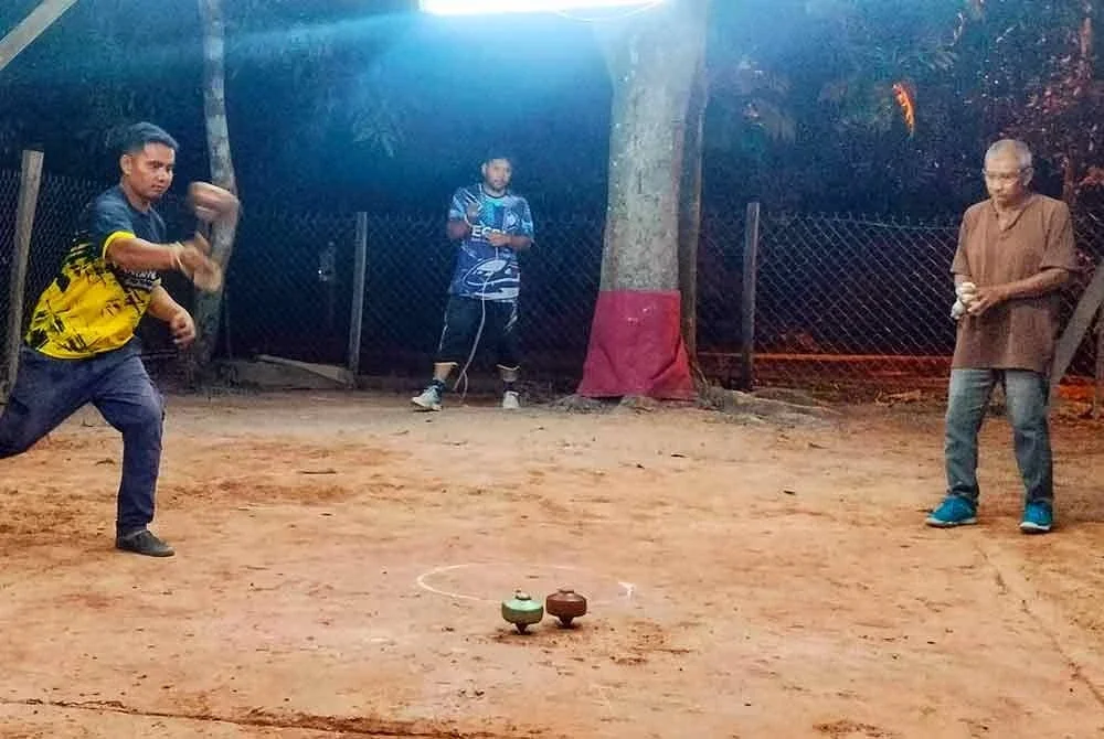 Salah seorang peserta menunjukkan kemahiran bermain gasing yang dimilikinya.