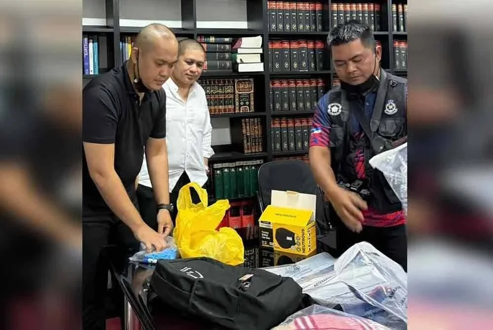 Hamid (dua dari kiri) menyaksikan pihak polis mengambil barang peribadi Zara Qairina.