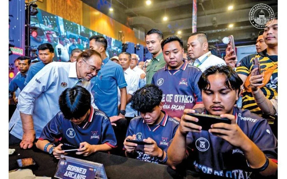 Perdana Menteri, Datuk Seri Anwar Ibrahim (kiri) melihat peserta Mobile Legends NAFAS NEKMAT di Segmen Agro Millenia.