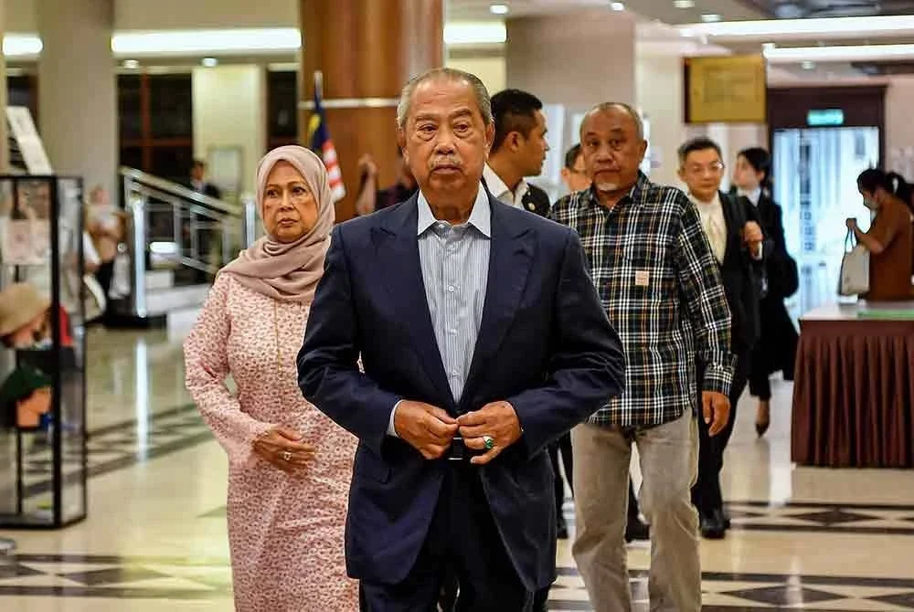Muhyiddin (tengah) tiba di Kompleks Mahkamah Kuala Lumpur pada Rabu bagi sebutan kes berhubung salah guna kedudukan dan menerima wang daripada aktiviti haram yang dihadapinya. Foto Bernama