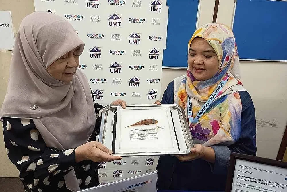 Dr Tun Nurul Aimi Mat Jaafar (kanan) menunjukkan spesimen ikan Baji Azizah yang pertama kali ditemui di dunia dalam ekspedisi penyelidikan dasar laut di perairan Laut China Selatan.