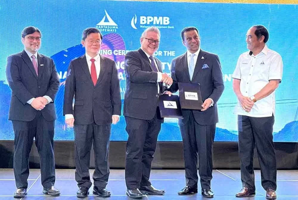 Ketua Kumpulan Liputan BPMB, Gerald Goh (tengah) dan Ravindran menandatangani perjanjian pembiayaan antara BPMP dan Hartasuma Ropeways Sdn Bhd sambil disaksikan Kon Yeow (dua dari kiri).
