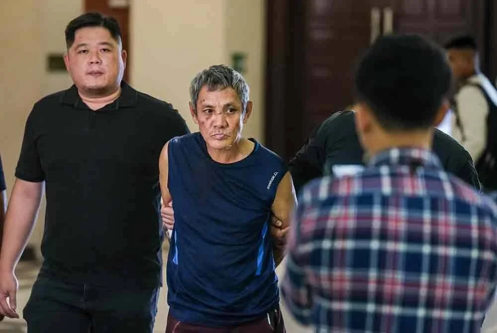 Thye Sun yang memakai baju T tanpa lengan berwarna biru (tengah), dibawa ke Mahkamah Sesyen Kuala Lumpur pada Rabu bagi menghadapi dua pertuduhan cubaan membunuh seorang anggota polis dan memiliki senjata berbahaya, minggu lalu.