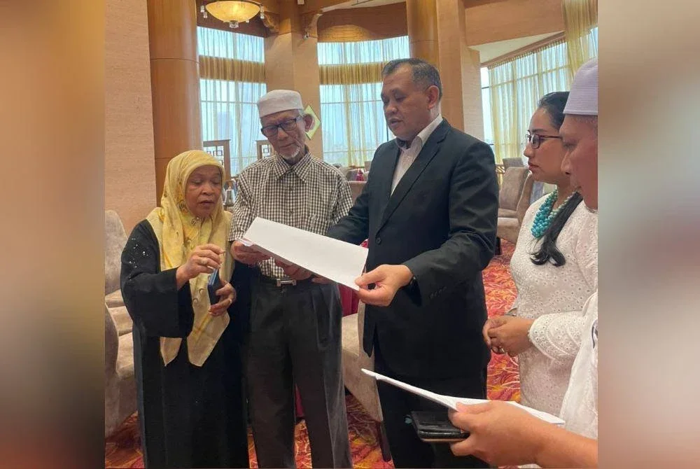 Ruhani dan suami (kiri) melihat dokumen yang ditunjukkan oleh Zulqarnain.