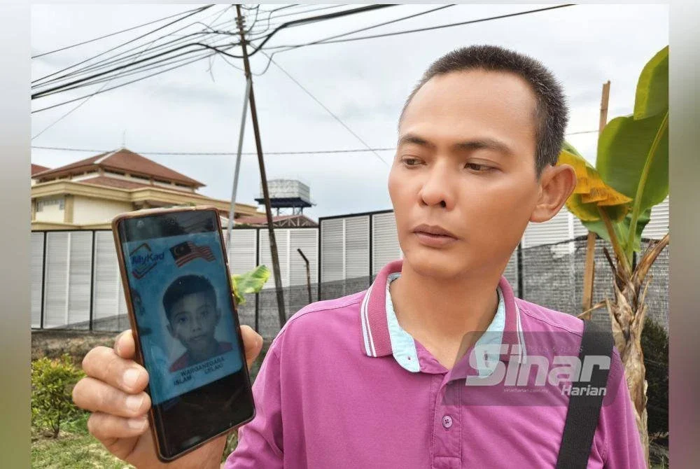 Che Faizal menunjukkan gambar Che Wan Muhammad Aqif Mustaqim yang maut dalam kejadian langgar lari pada pagi Rabu.