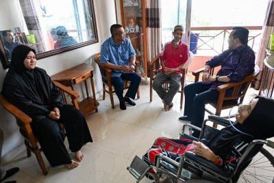 Asyraf Wajdi (dua dari kanan) berbual dengan Ah Yauddin (tengah) ketika mengunjungi kediaman mereka di Meru, Kapar pada Rabu.
