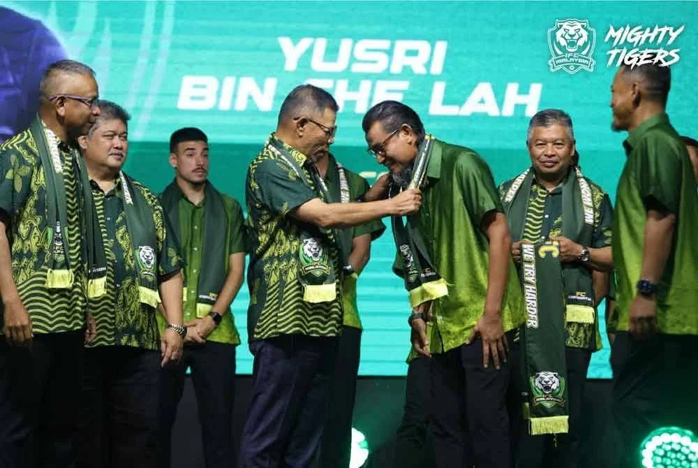 Menteri Dalam Negeri, Datuk Seri Saifuddin Nasution Ismail memakaikan mafla Imigresen FC kepada Yusri pada pengenalan pasukan tersebut di sebuah hotel Alor Setar pada malam Rabu. FOTO IMIGRESEN FC