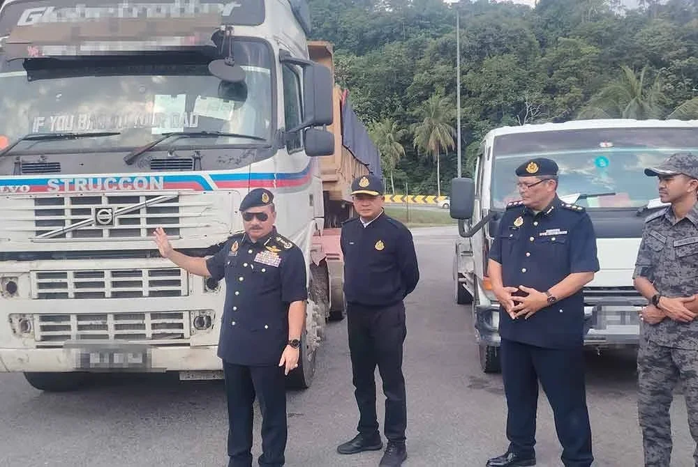 Muhammad Kifli (kiri) menunjukkan lori yang dipandu lelaki warga asing menggunakan MyKad dan lesen palsu.