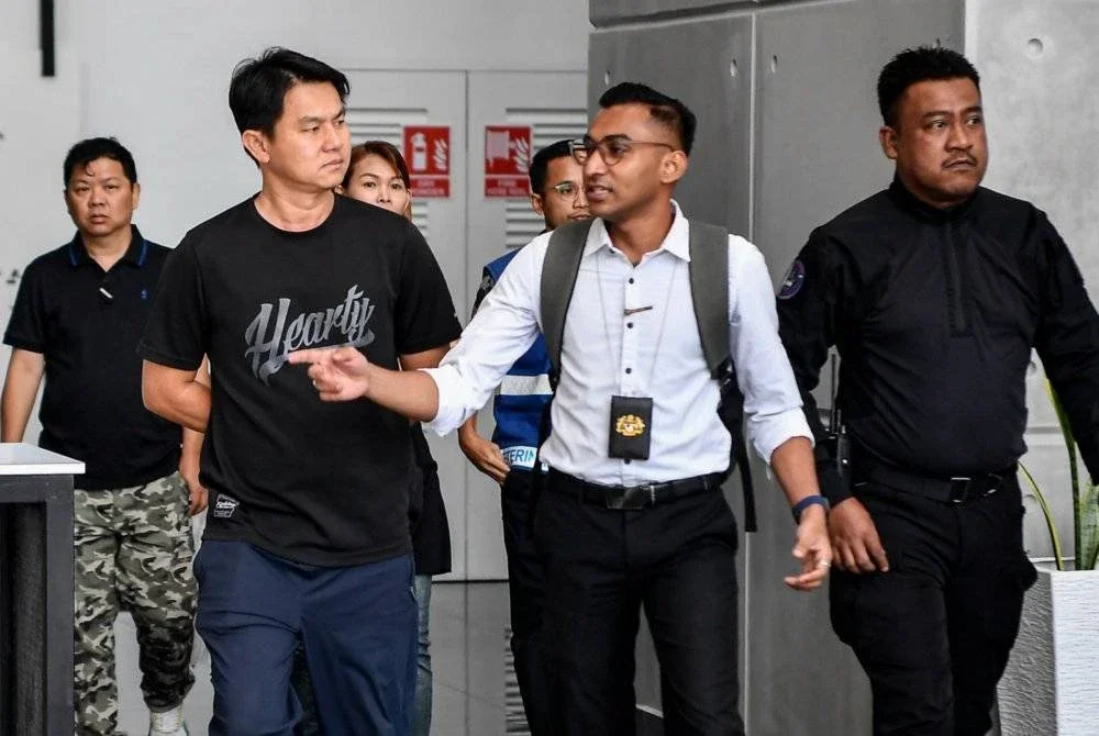 Seorang lelaki (depan, kiri) yang tular kerana memukul anjing peliharaannya, ‘Lucky’, menggunakan rotan kayu dan getah paip, didenda RM30,000 oleh Mahkamah Sesyen Ampang pada Khamis, selepas mengaku bersalah atas pertuduhan tersebut. Foto Bernama