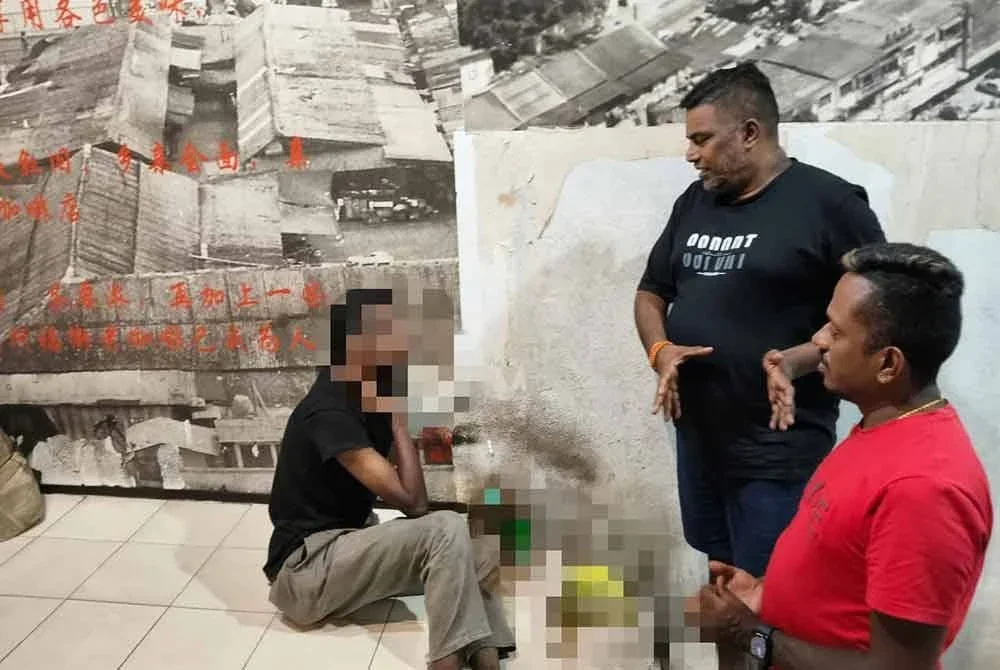 RAM (duduk, kiri) bercerita tentang kejadian video tular kepada beberapa pengunjung yang menegurnya di sekitar pusat bandar Johor Bahru.