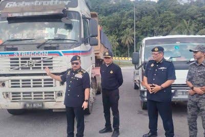 Muhammad Kifli (kiri) menunjukkan lori yang dipandu lelaki warga asing menggunakan MyKad dan lesen palsu.