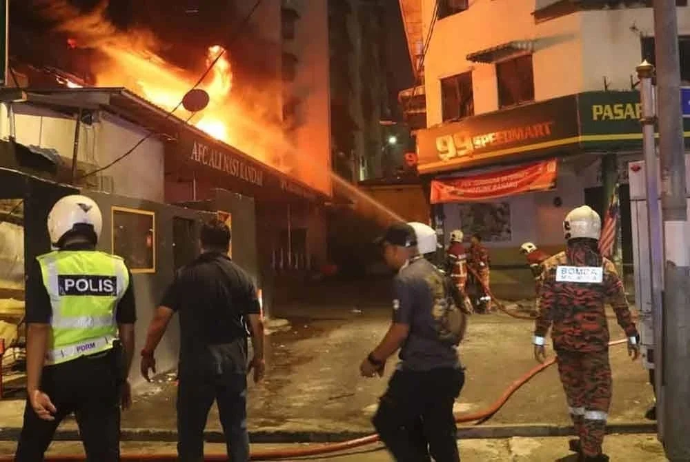Anggota bomba berusaha memadamkan kebakaran di JalanPantai Dalam, Kuala Lumpur pada Khamis.