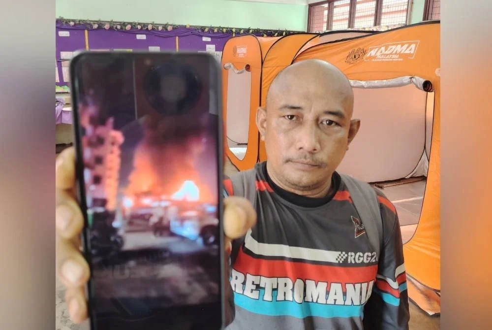 Wan Mazlan menunjukkan rakaman video api marak di penempatan setinggan di Jalan Pantai Dalam, Kuala Lumpur.